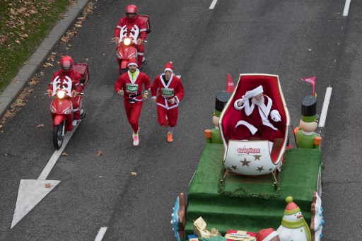 People dressed in Santa Claus costumes participate in the six kilometre charity race to raise funds for multiple sclerosis research, in Madrid on December 17, 2016.   / AFP PHOTO / CURTO DE LA TORRE